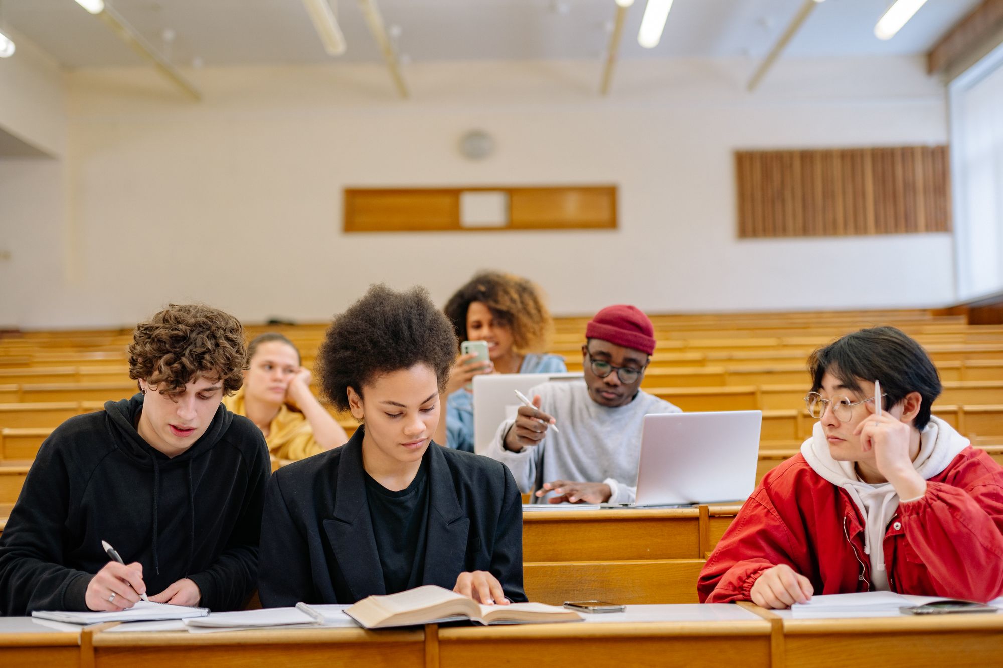 Groupe d'étudiants suivant un cours et prenant des notes